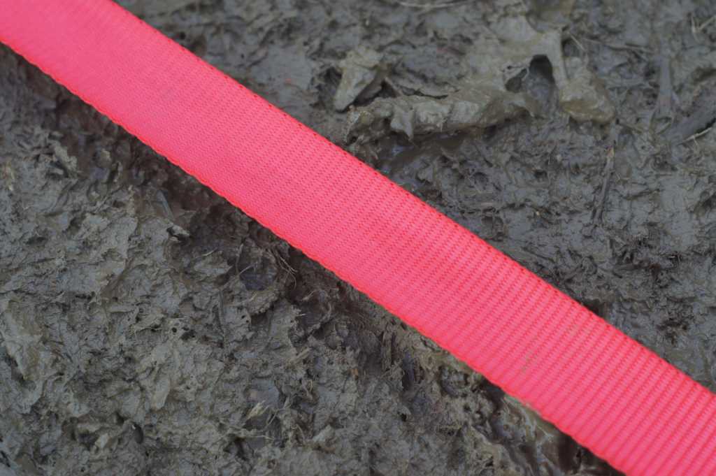 ein sauberes rotes Begrenzungsband liegt auf den Schlamm