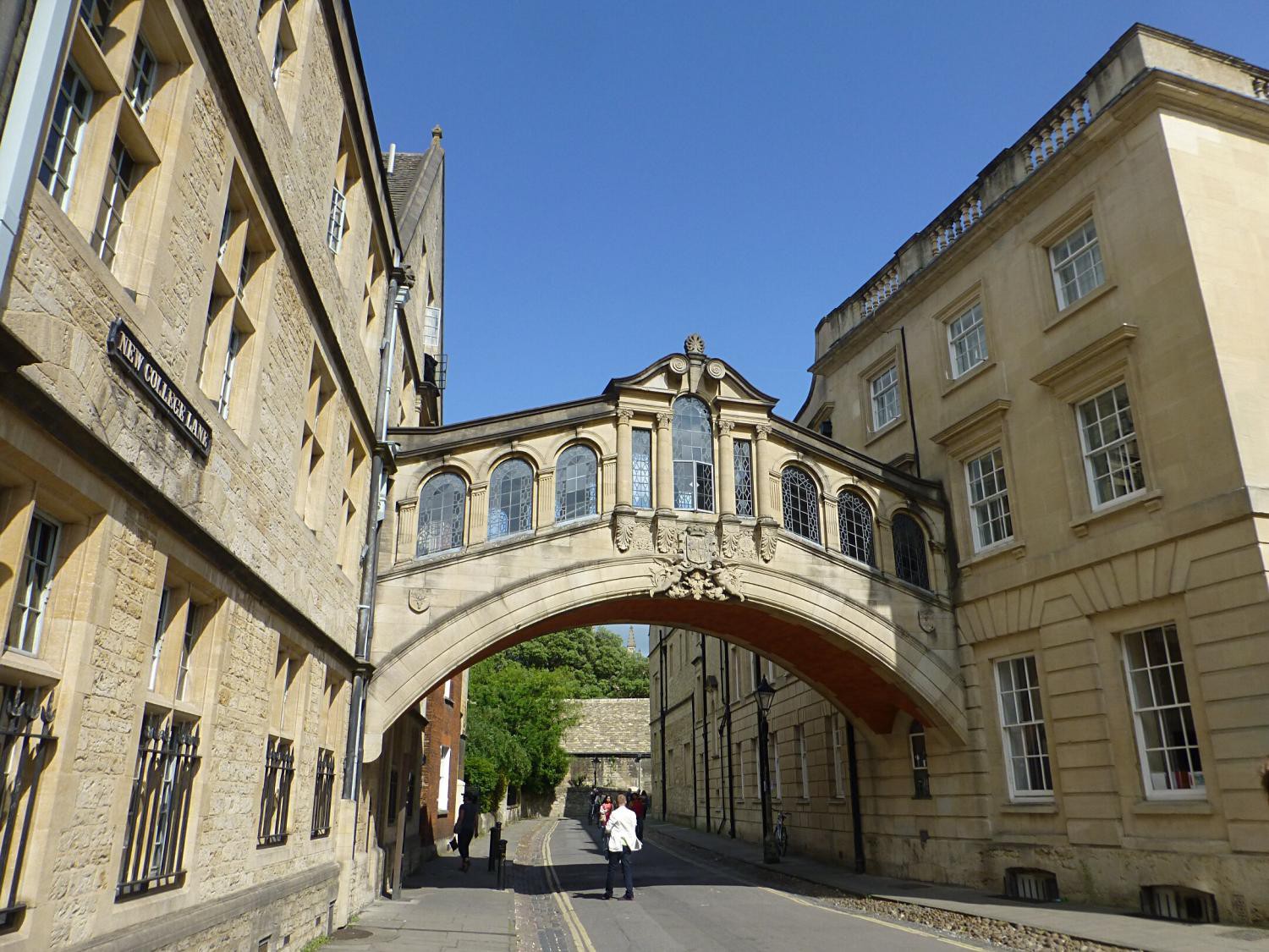 zwei Häuser die mit einer Brücke über eine Straße verbunden sind