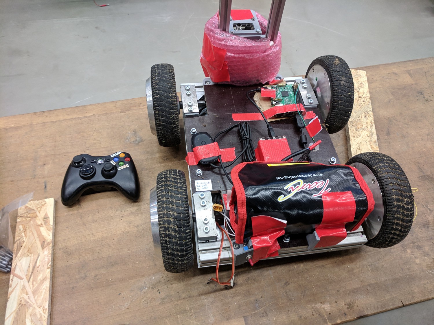 Grundplatte mit den vier Hoverboard Motoren und Akku Pack. Ein XBox 360 Controller liegt daneben.